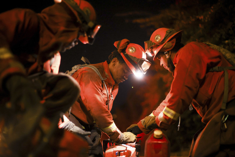 A California Department of Corrections hand crew works containment lines ahead of the Palisades Fire Tuesday, Jan. 14, 2025 in Santa Monica, Calif. 