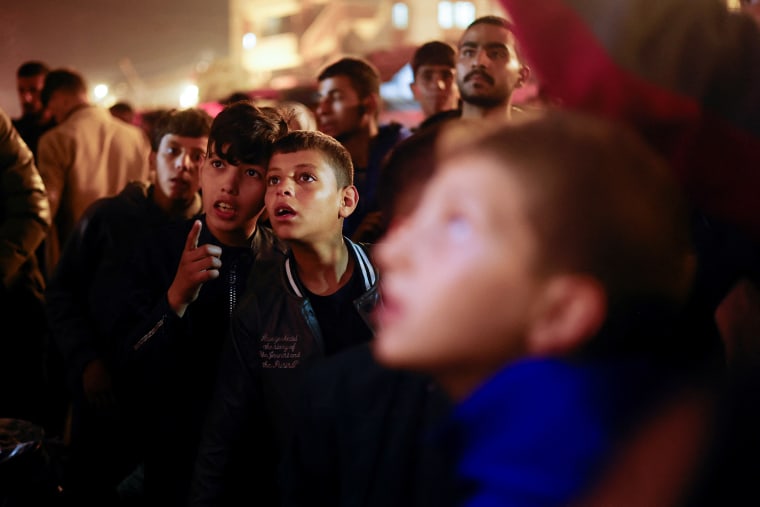 Palestinians react as they wait for news of a ceasefire deal with Israel, in Khan Younis in the southern Gaza Strip