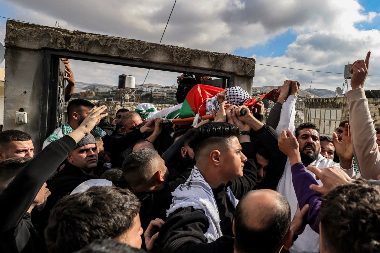 Pessoas em luto carregam corpo do adolescente palestino Ahmad Rushdi