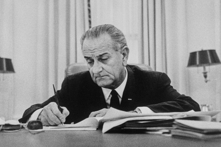 Lyndon Johnson Signing Paper at Desk.