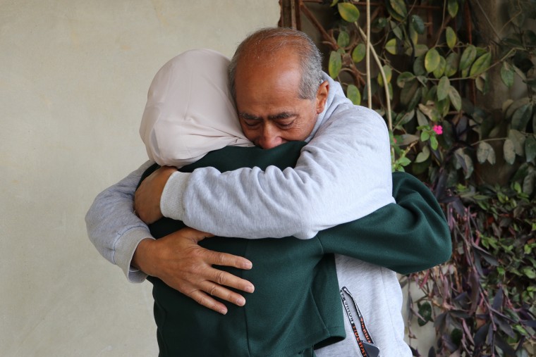 Jeneen Amro, 23, hugs a relative, Raef Mohammed Amro