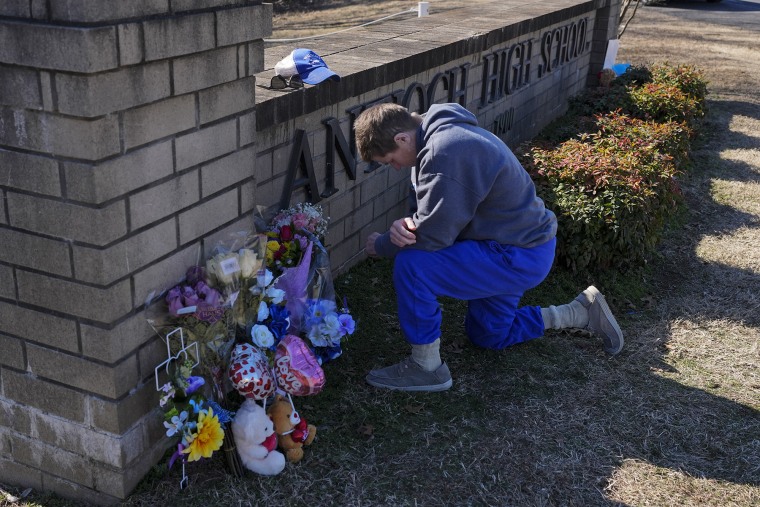 Kristi Rainwater kneels in prayer Thursday at a memorial for victims of a shooting at Antioch High School 