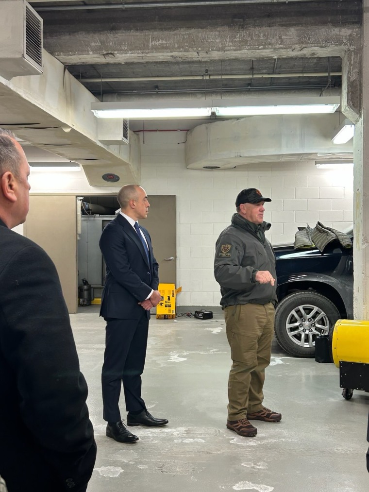 Emil Bove, left, and Tom Homan stand in a parking garage