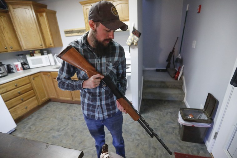 Nic Talbott checks his pump shotgun at his home in Lisbon, Ohio. 