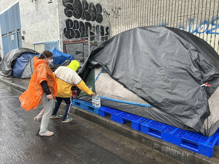 Water Drop LA volunteers leave two gallon jugs near a Skid Row resident's tent.