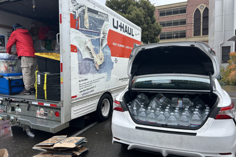 Water Drop LA volunteers unload water into volunteers' cars before going to Skid Row