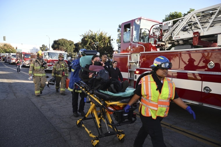 Una mujer es trasladada en una camilla cerca del sitio donde un avión se estrelló, el jueves 2 de enero de 2025, en Fullerton, California. 