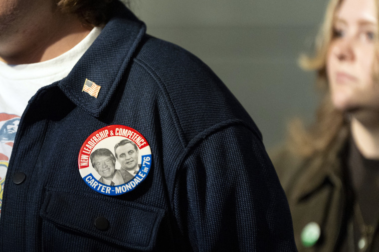 A mourner wears a Carter-Mondale button