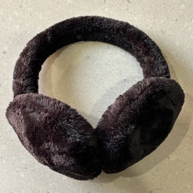 Black fuzzy earmuffs from Muji lying on a table.