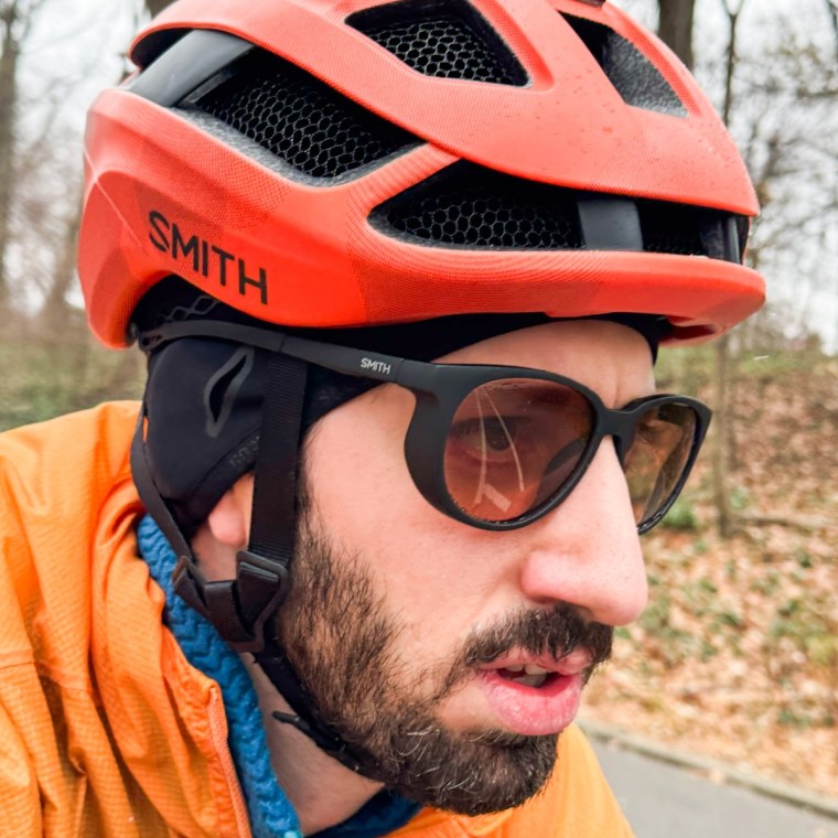 A headshot of Rabinowitz wearing the Smith Seeker sunglasses and a helmet while riding his bike outdoors.