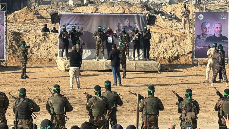 Yarden Bibas, center in red, is escorted by Hamas militants onto a stage.