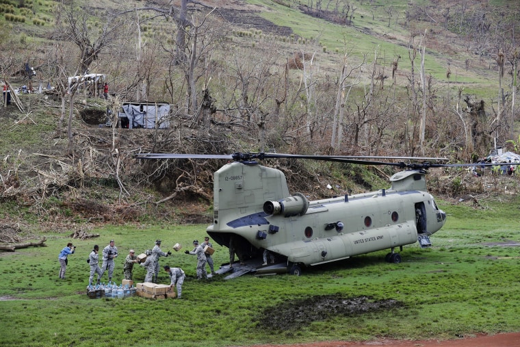 U.S. military personnel unload USAID relief supplies from a helicopter in Haiti after Hurricane Matthew.