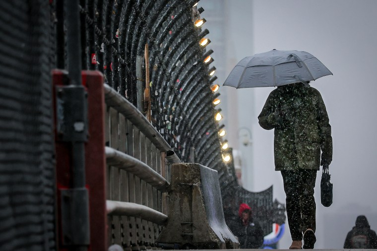 A person with an umbrella in the snow.