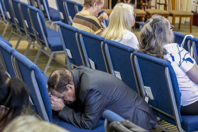 A congregant kneels in prayer.