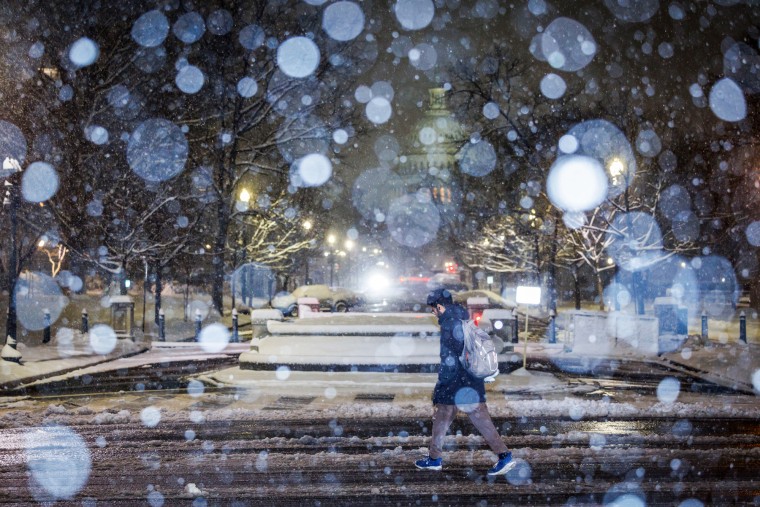 A pedestrian treks through the snow covered streets