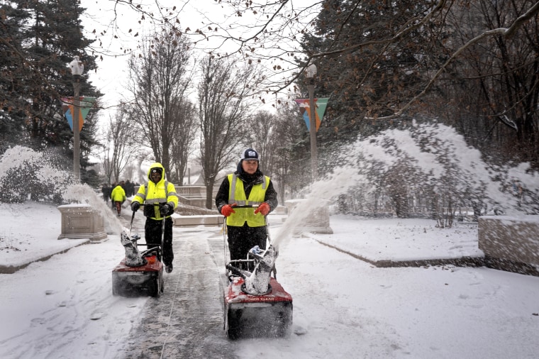 Workers clear snow.