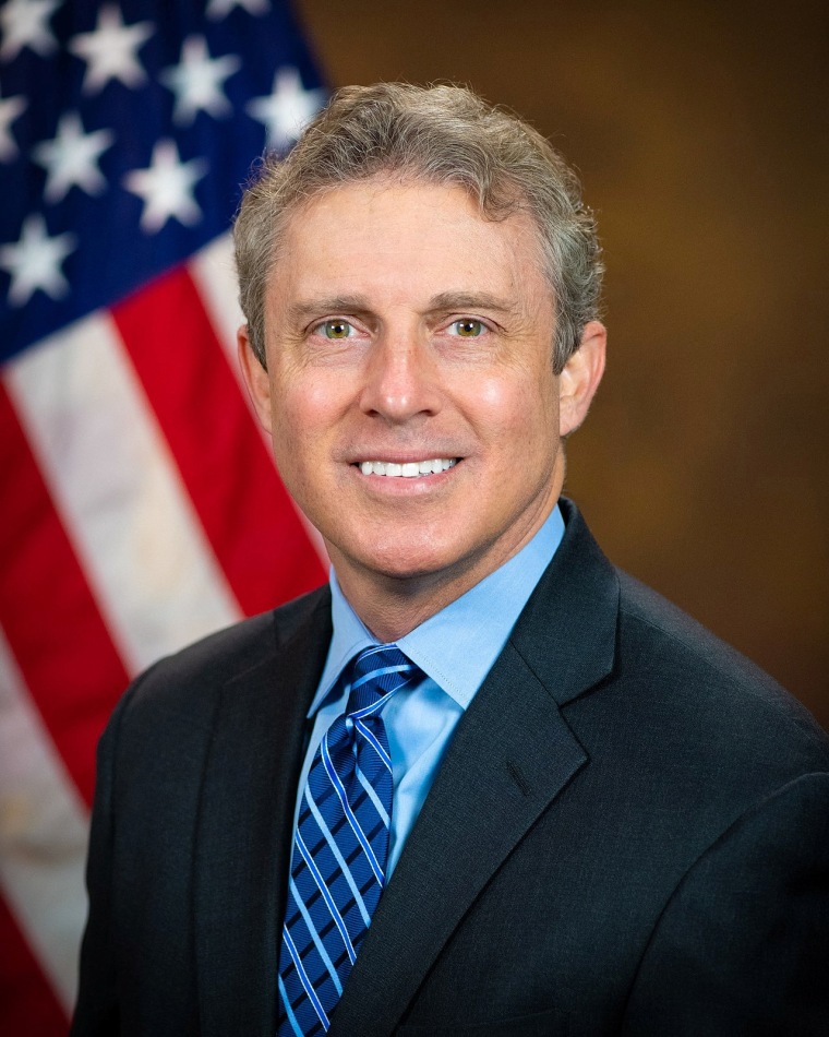 Hampton Dellinger smiles for a portrait, American flag in background