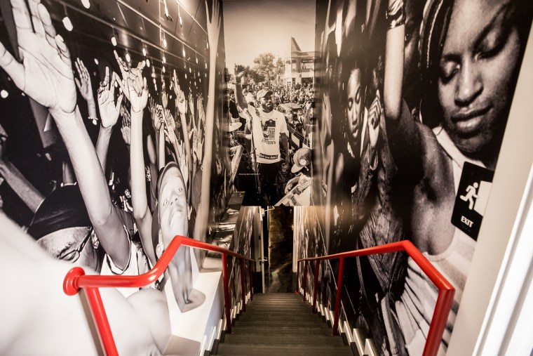 A staircase adorned with wallpaper showing black and white portraits of people dancing