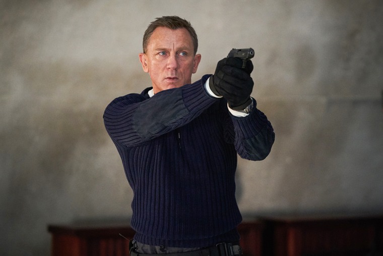 Daniel Craig aims a black handgun