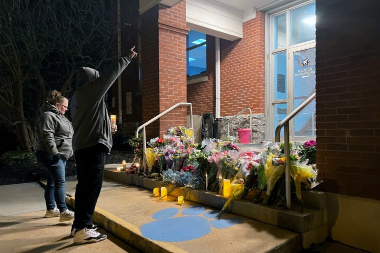 Two community members leave a prayer candle outside the West York District Police Station to remember Officer Andrew Duarte.