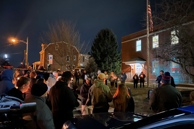 Community members gather outside the West York Borough Police Station to remember and honor Officer Andrew Duarte with prayers, flowers and candles.