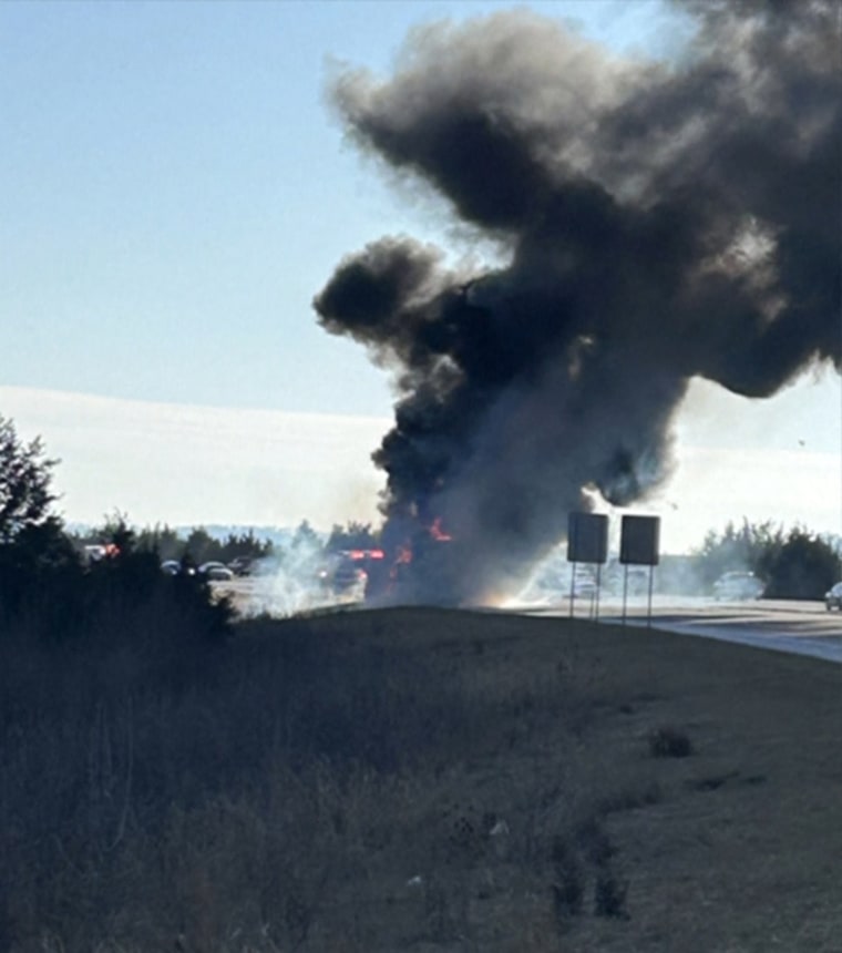 A cloud of smoke is seen in the distance on the highway