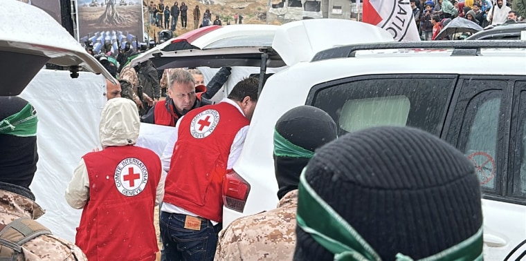 Red Cross workers load coffins in the car