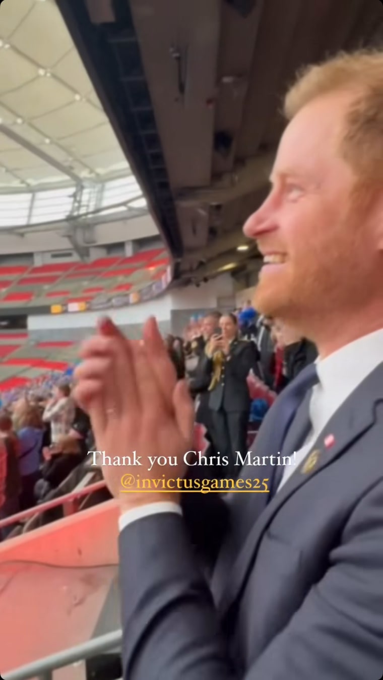 Pangeran Harry bersorak di Chris Martin dari kerumunan.