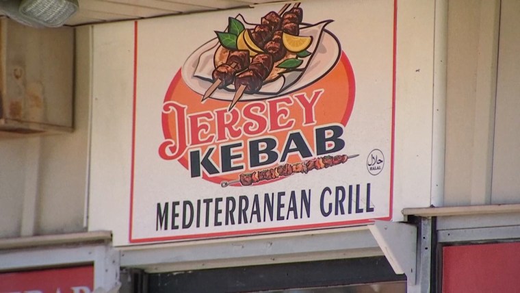 Storefront sign for Jersey Kebab Mediterranean Grill, showing an illustration of two kebabs on a plate on top of text that says "Jersey Kebab"