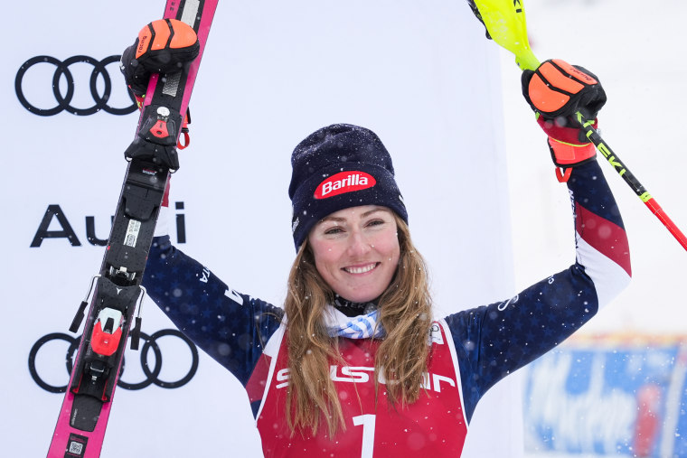 Mikaela Shiffrin holds up two skis in celebration