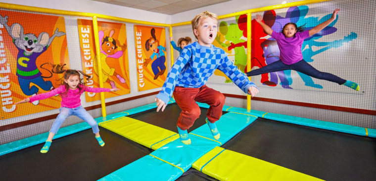 Children jump on a trampoline in Chuck E. Cheese.