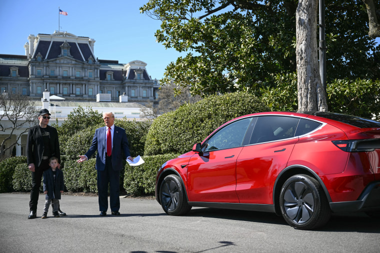 Image: President Donald Trump, alongside Tesla CEO Elon Musk, speaks next to a Tesla vehicle on the South Portico of the White House