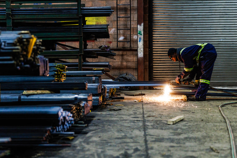 A worker cuts a piece of steel for a customer at North York Iron, a steel supplier in Toronto