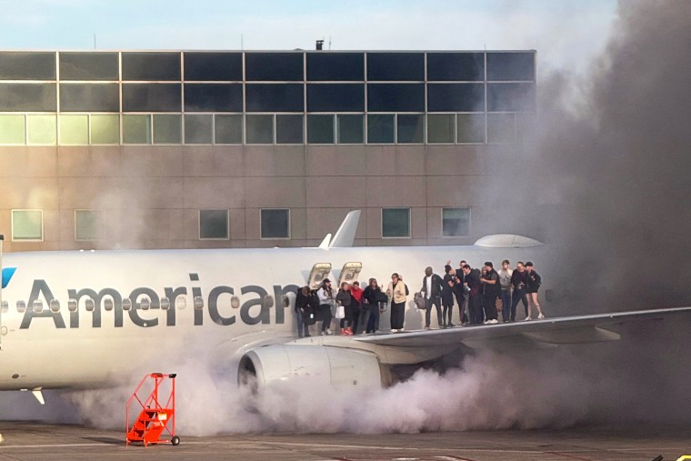 Image: plane accident fire smoke passengers wing evacuation