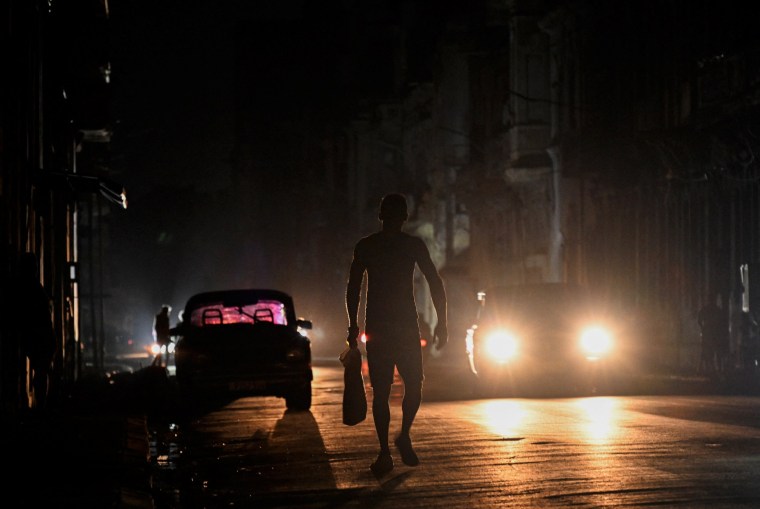 Image: A man walks on a street during a general blackout in Havana on March 14, 2025.
