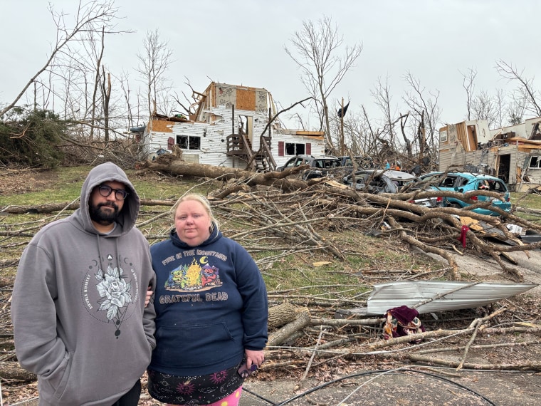 Joy and Hassan Azddou stand in front of their house