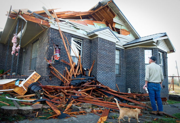 Kerry Walker checks damage to his home in near Plantersville, Ala.,  after a tornado