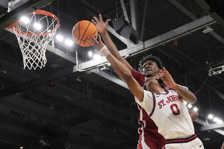 Arkansas forward Karter Knox, rear, reaches over St. John's guard Aaron Scott