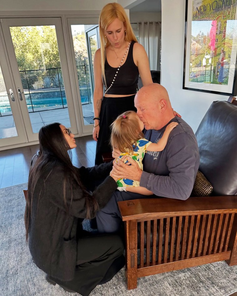 Demi Moore y Rumer Willis miran mientras Bruce Willis parece compartir un beso con su nieta, Louetta.
