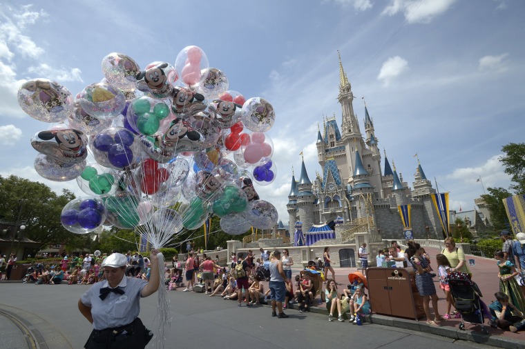 Un miembro del elenco vende globos frente al Castillo de Cenicienta en el parque temático Magic Kingdom de Walt Disney World en Lake Buena Vista, Florida, el sábado 10 de mayo de 2014.