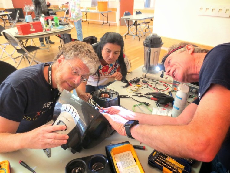 Volunteers at a Fixit Clinic in Berkeley, Calif., work on repairing a multicooker.