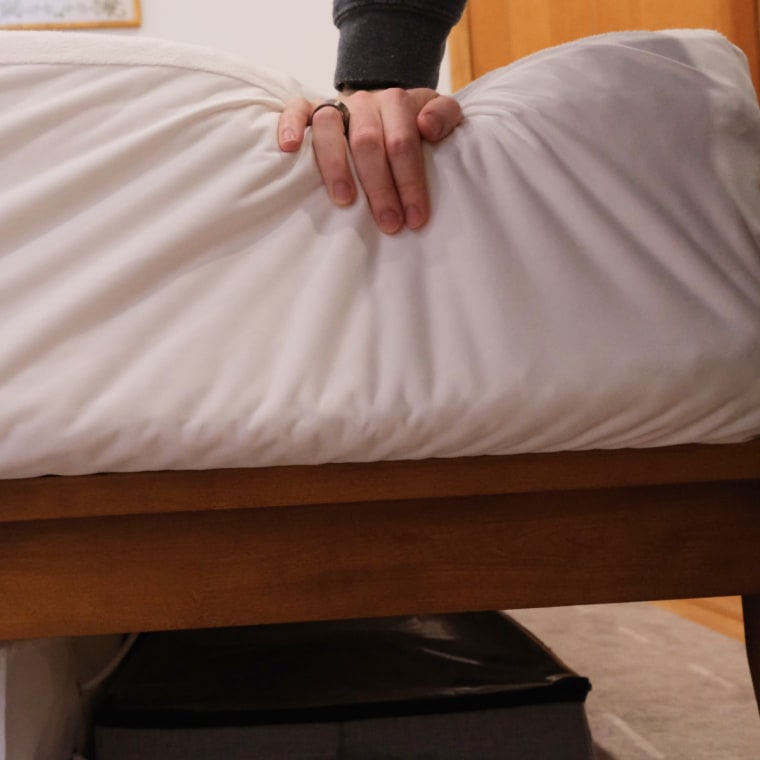 Profile of the Leesa Sapira mattress with hand pressing down on it.