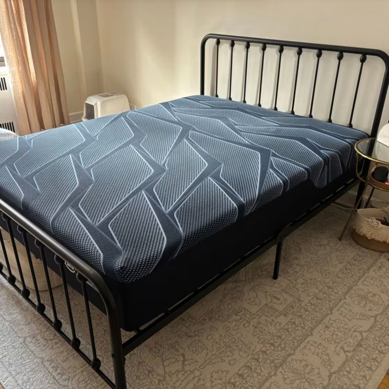 Serta iSeries mattress on a bed frame without a cover on it.