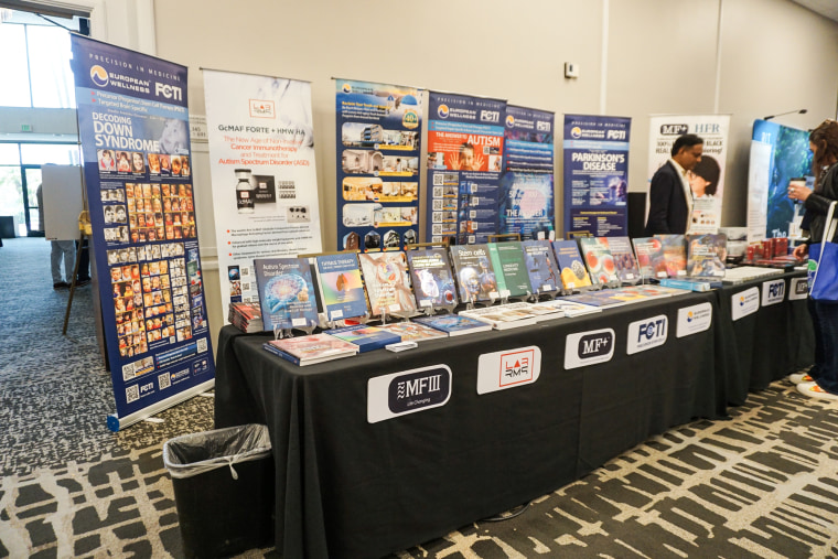 Signs are posted up behind a booth at a conference hall