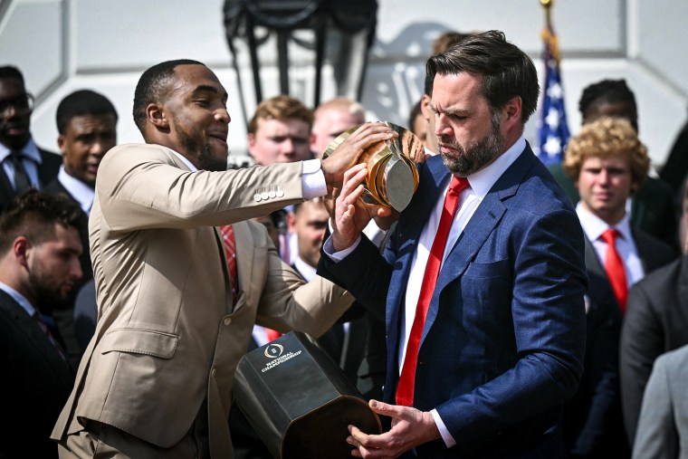 Image: Running back TreVeyon Henderson and Vice President JD Vance bobble the College Football Playoff National Championship Trophy