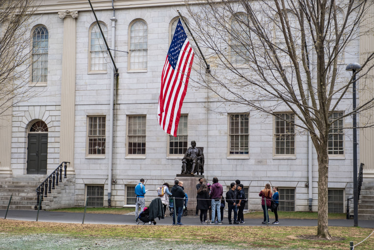 Image: People gather around the John Harvard Statue on the Harvard University campus