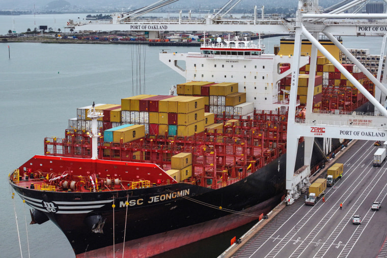In an aerial view, a container ship docked.