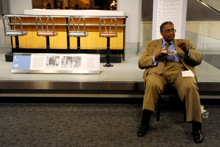 Dr. Franklin McCain, one of the Greensboro Four, sits and eats in front of the  lunch counter