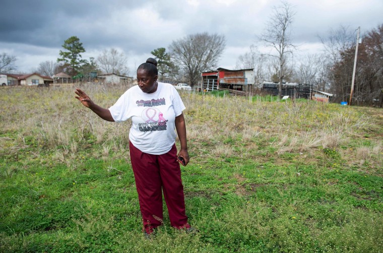 Perman Hardy shows where sewage used to be dumped behind her and her neighbors' homes in Lowndes County, Ala., in 2022.