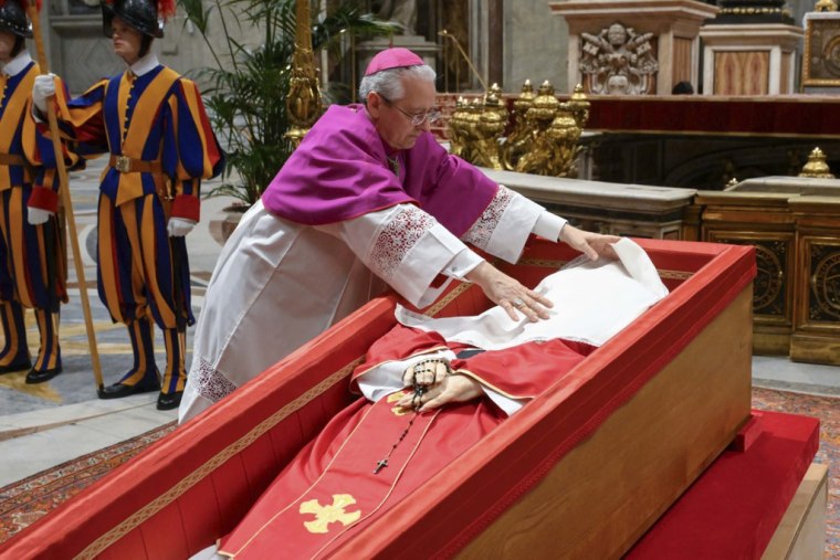 El maestro de ceremonias del Vaticano, el arzobispo Diego Giovanni Ravelli, cubre el rostro del difunto papa Francisco con un paño de seda antes de cerrar su ataúd en la basílica de San Pedro, en el Vaticano, el 25 de abril de 2025.